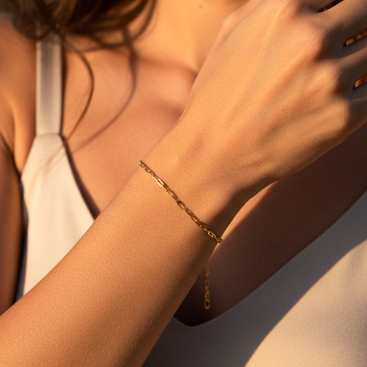 Mano de mujer usando una pulsera en tejido classic franco de 18 quilates de Joyería Caracas. 