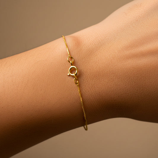Mano de mujer usando una pulsera en tejido classic venecia en oro amarillo de 18 quilates de Joyería Caracas. 