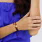 Mano de mujer usando pulsera tejida en hilo de color rojo con accesorios del mismo color y un herraje en el centro de la virgen de Guadalupe con cristales de color blanco alrededor en oro amarillo de 18 quilates.