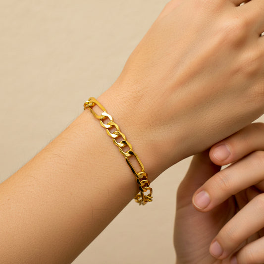 Mano de mujer usando una pulsera en tejido Cubano 3x1 L en oro amarillo de 18 quilates de Joyería Caracas. 
