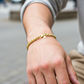 Mano de una modelo usando una pulsera tejido cubano en oro amarillo con cristal de Joyería Caracas.