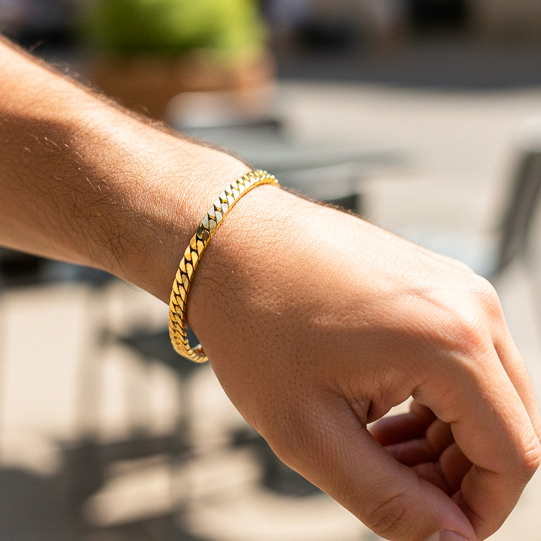 Mano de una modelo usando una pulsera cubana martillada en oro amarillo con cristal de Joyería Caracas.
