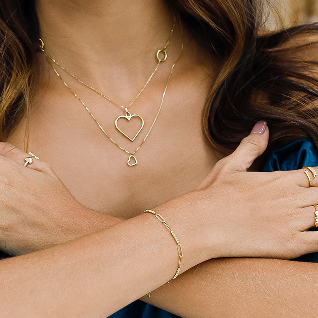 Mano de mujer usando una pulsera de clips con mini esferas en oro amarillo de 18 quilates.