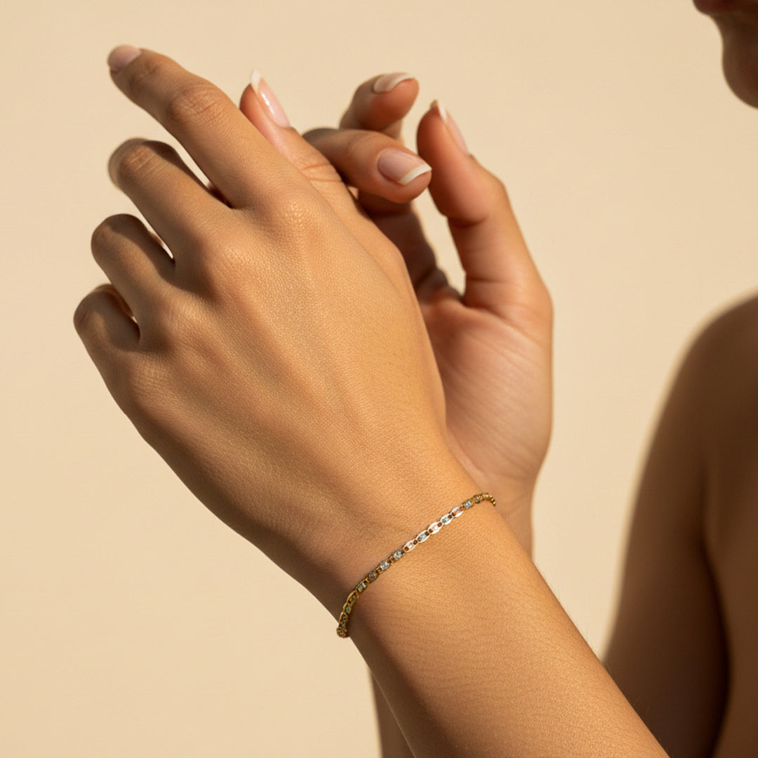 Mano de mujer usando una pulsera tejido escalera plana 3 oros de 18 quilates de Joyería Caracas. 