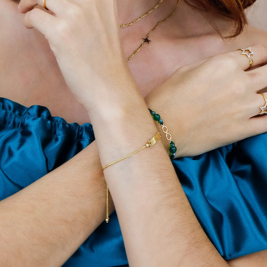Mano de mujer usando una pulsera con esclava cierre de esfera en oro amarillo de 18 quilates en Joyería Caracas.