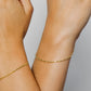 Mano de mujer usando pulsera de tejido Singapur en oro amarillo de 18 quilates en Joyería Caracas. 