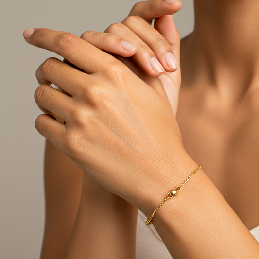 Mano de mujer usando una pulsera de enlace único en oro amarillo de 18 quilates de Joyería Caracas. 