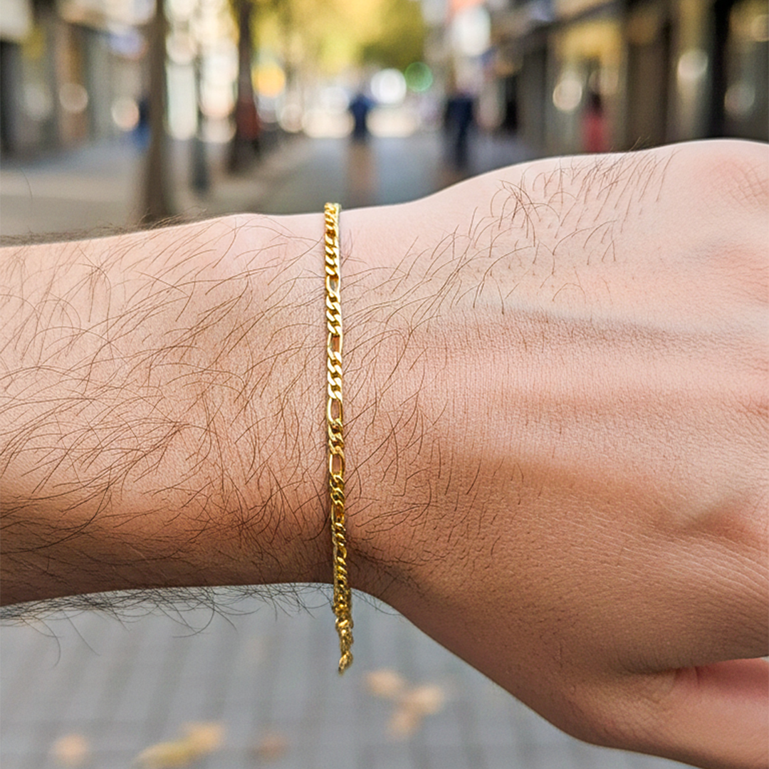 Mano de una modelo usando una pulsera cubana 3x1 S en oro amarillo con de Joyería Caracas.