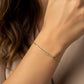 Mano de mujer usando una pulsera en oro amarillo de 18 quilates con cristales de color blanco de Joyería Caracas. 