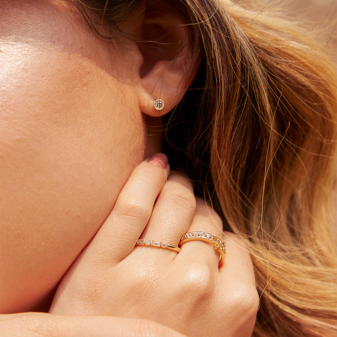 Oreja de mujer con topito en forma empalillado en oro amarillo de 18 quilates con cristal de color blanco, hechos en Joyería Caracas. 