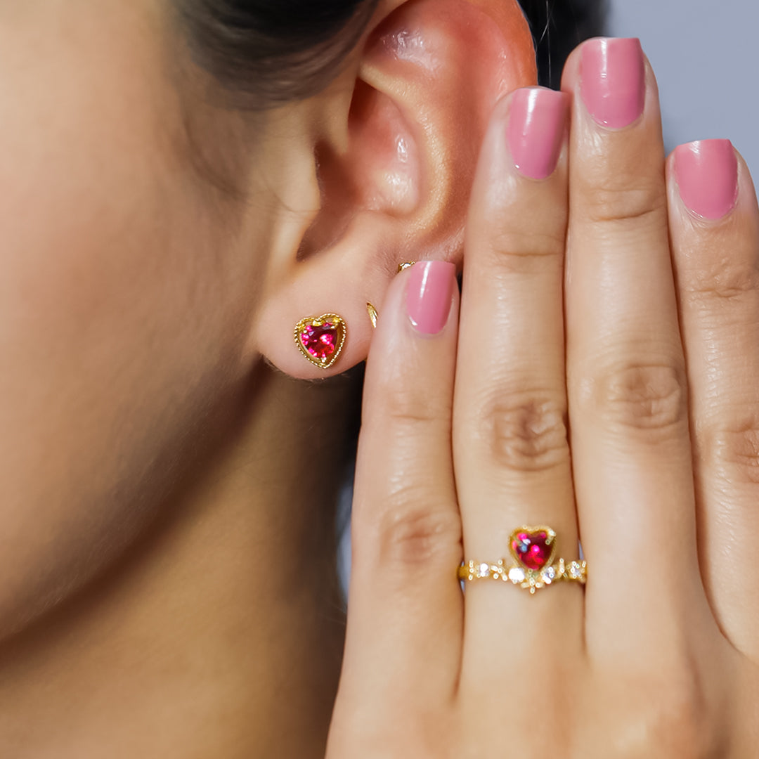 Oreja de mujer con topito en oro amarillo de 18 quilates con cristal de color rojo en forma de corazón, hechos en Joyería Caracas. 