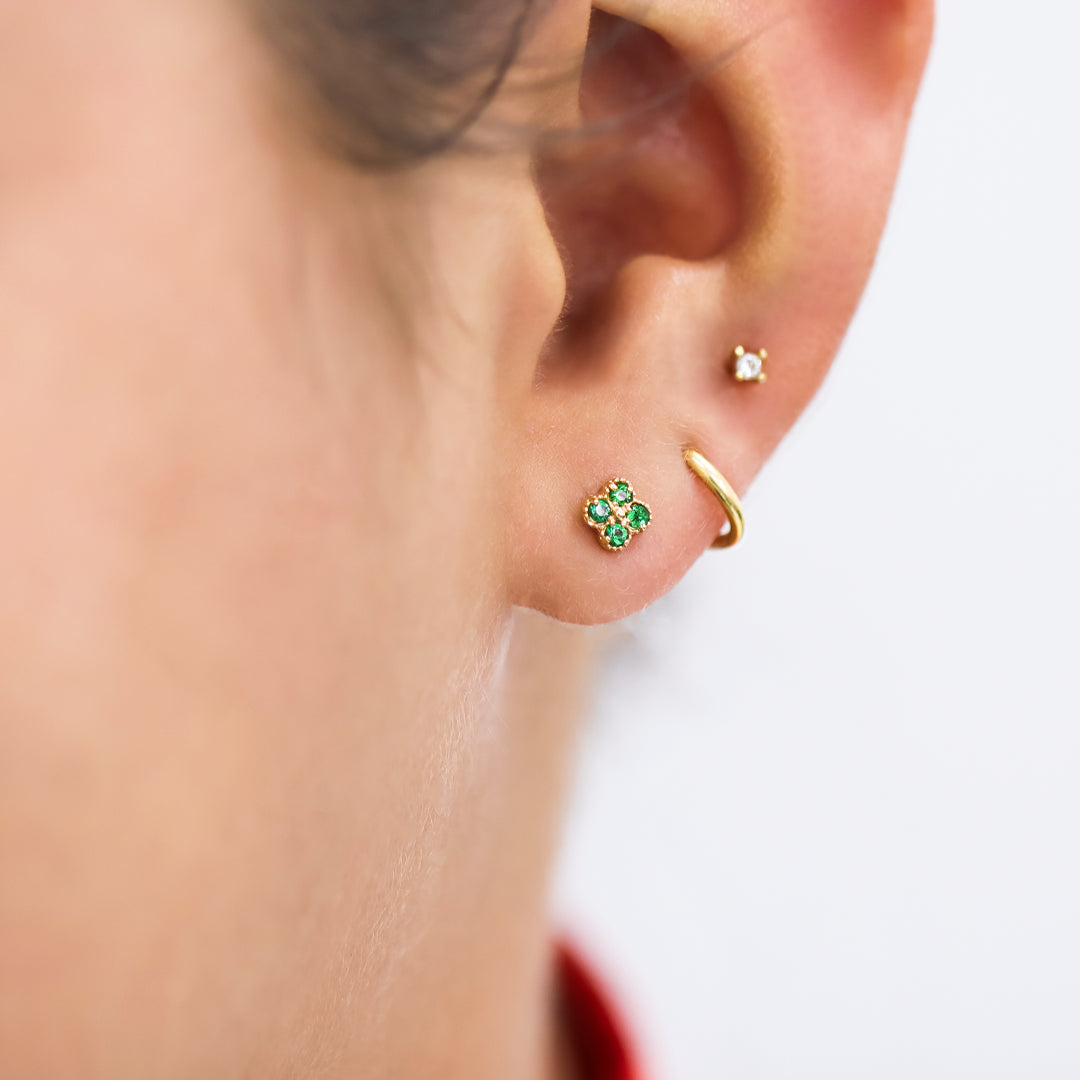 Oreja de modelo usando un piercing de aro en oro amarillo de 18 quilates de Joyería Caracas.