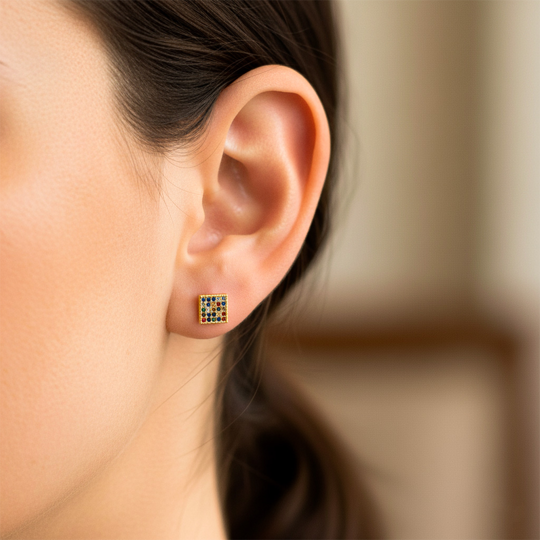 Oreja de modelo usando un topito en forma cuadrada en oro amarillo de 18 quilates con cristales de distintos colores de Joyería Caracas.