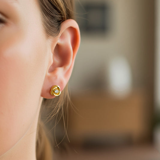 Oreja de modelo usando un topito en forma de espiral en oro amarillo de 18 quilates con cristal de color blanco de Joyería Caracas-