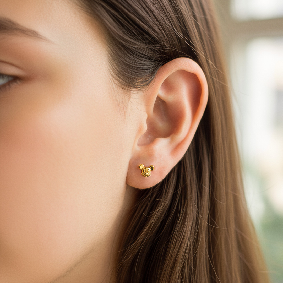 Oreja de modelo usando un topito de Mickey Mouse en oro amarillo de 18 quilates de Joyería Caracas. 