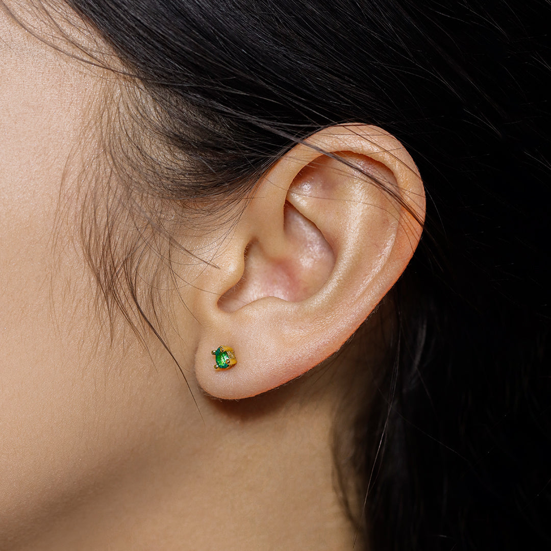 Oreja de mujer con topito en forma de gota en oro amarillo de 18 quilates con esmeralda, hechos en Joyería Caracas. 