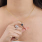 Cuello de mujer usando una cadena con dije en forma de trébol en oro amarillo de 18 quilates y piedra en forma de trébol en color negro de Joyería Caracas.