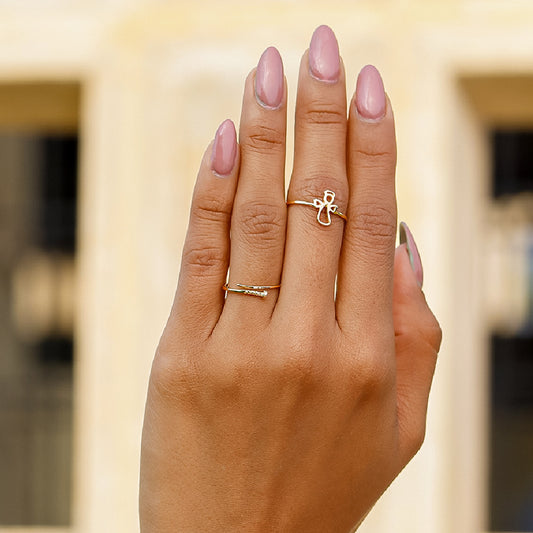 Mano de mujer usando anillo con un ángel en el centro en oro amarillo de 18 quilates, hecho en Joyería Caracas. 