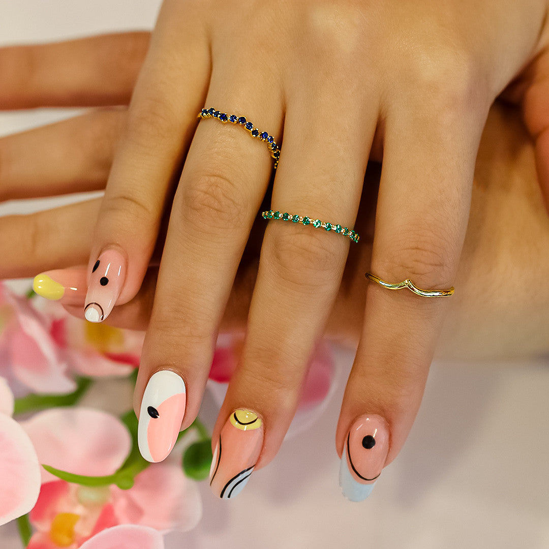 Mano de mujer con anillo en oro amarillo de 18 quilates con cristales de color verde, hecho en Joyería Caracas. 