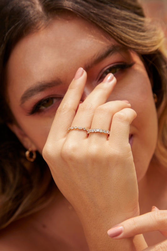 Mano de mujer con anillo en oro amarillo de 18 quilates con piedras preciosas de diamantes de color blanco, hecho en Joyería Caracas. 