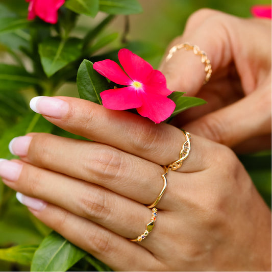 Mano de mujer con anillo en forma de infinitos entrelazados en oro amarillo de 18 quilates, hecho en Joyería Caracas. 