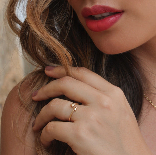 Mano de mujer con anillo en forma de flecha en oro amarillo de 18 quilates, hecho en Joyería Caracas. 