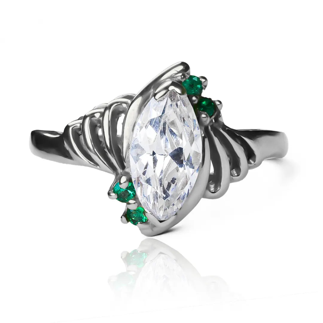Anillo Marquise Esmeraldas de Joyería Caracas. Fabricado en oro 18k, cuenta con acabados de lujo y un diseño exclusivo en forma de marquesa con brillantes esmeraldas. Con garantía para toda la vida.