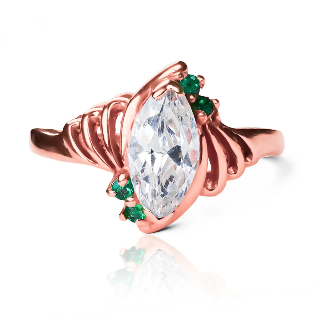 Anillo Marquise Esmeraldas de Joyería Caracas. Fabricado en oro 18k, cuenta con acabados de lujo y un diseño exclusivo en forma de marquesa con brillantes esmeraldas. Con garantía para toda la vida.