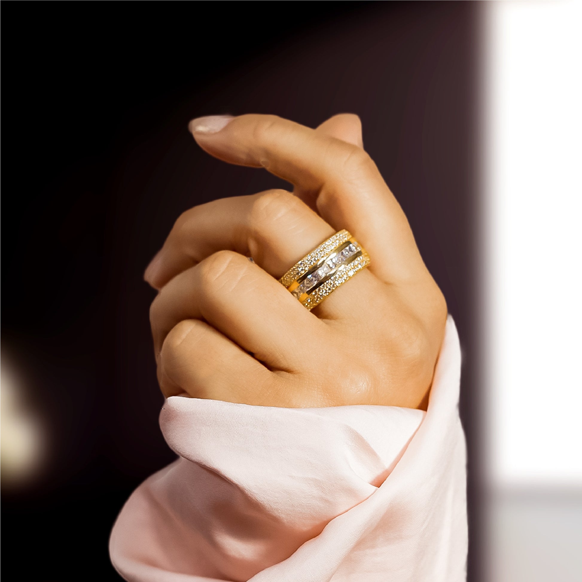 Mano de mujer con anillo en oro amarillo de 18 quilates con cristales de color blanco, hecho en Joyería Caracas. 