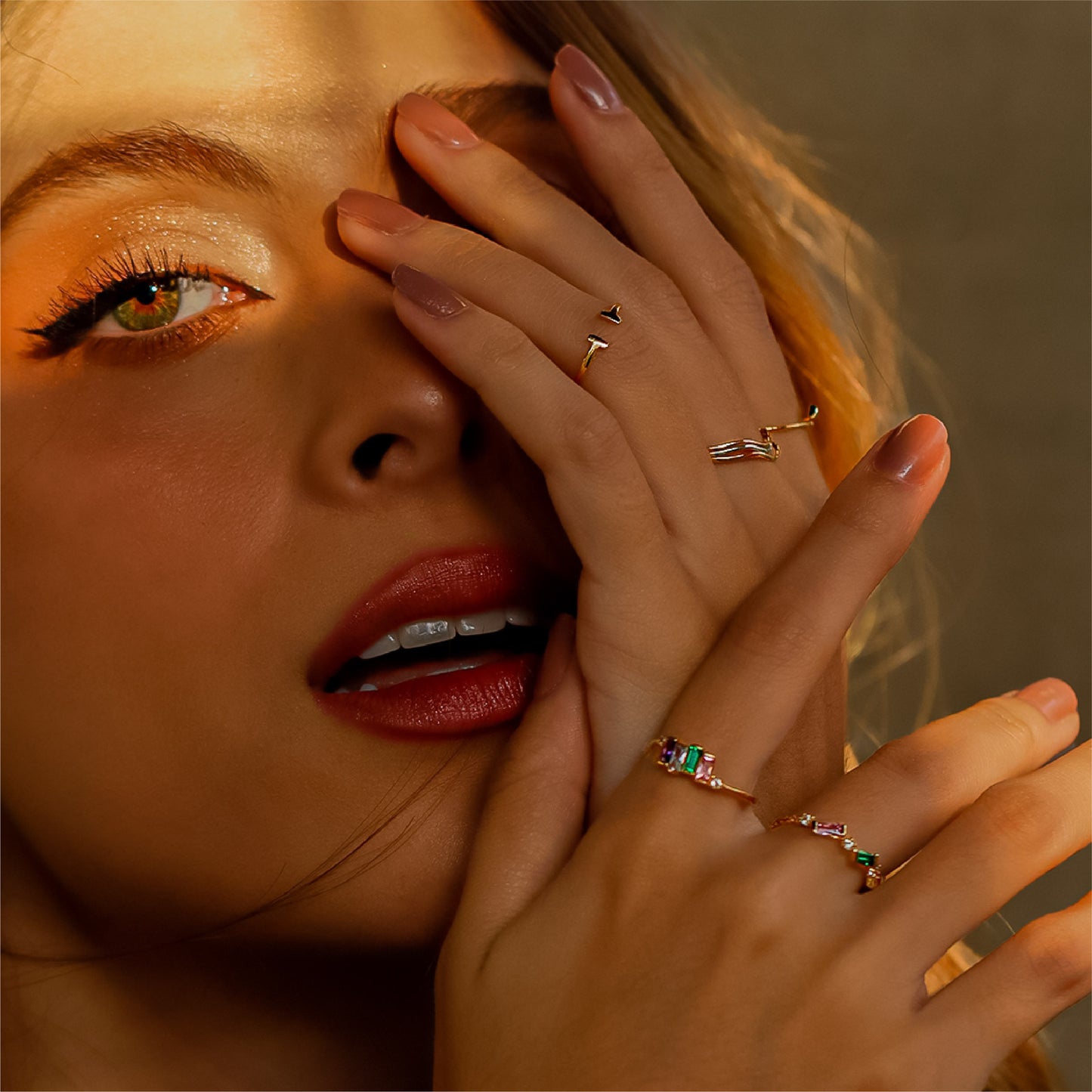 Mano de mujer con anillo en oro amarillo de 18 quilates con cristales de distintos colores, hecho en Joyería Caracas. 