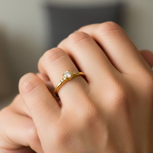 Mano de mujer usando un anillo diseño Éclat de Trois en oro amarillo de 18 quilates con Moissanites de color blanco de Joyería Caracas. 