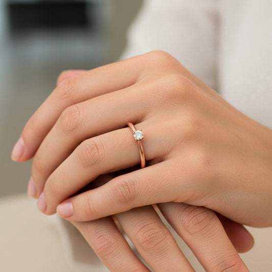 Mano de mujer usando un anillo solitario en oro rosado de 18 quilates con Diamante de color blanco en el centro de Joyería Caracas.