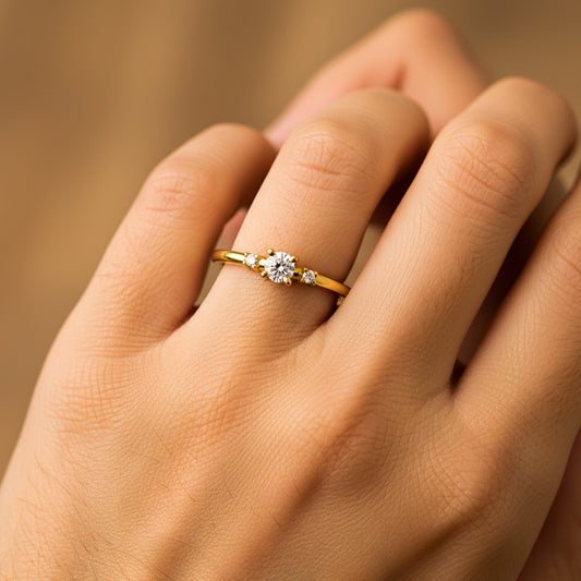 Mano de mujer usando un anillo en oro amarillo de 18 quilates con Diamantes de color blanco de Joyería Caracas. 