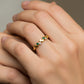 Mano de mujer usando un anillo con formas de ramas en oro amarillo de 18 quilates y Esmeraldas de Joyería Caracas. 