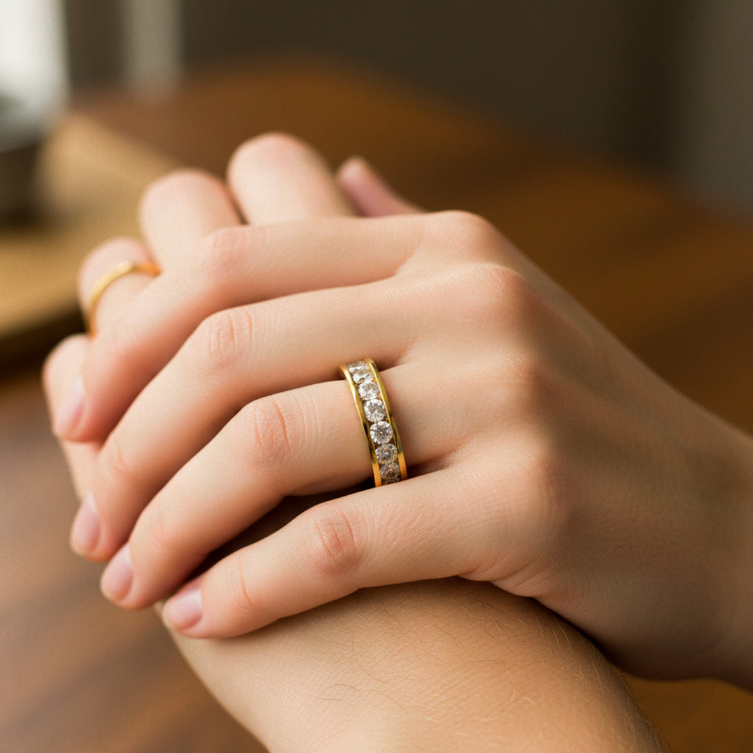Mano de mujer usando un anillo en oro amarillo de 18 quilates con cristales de color blanco alrededor de Joyería Caracas. 