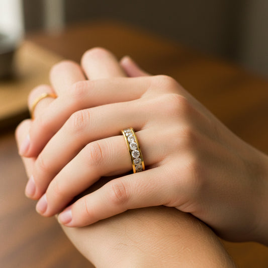 Mano de mujer usando un anillo en oro amarillo de 18 quilates con cristales de color blanco alrededor de Joyería Caracas. 
