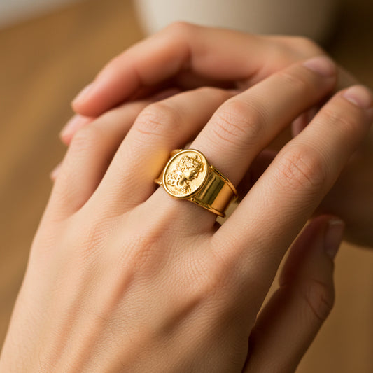 Mano de mujer usando un anillo camafeo clásico en oro amarillo de 18 quilates de Joyería Caracas. 