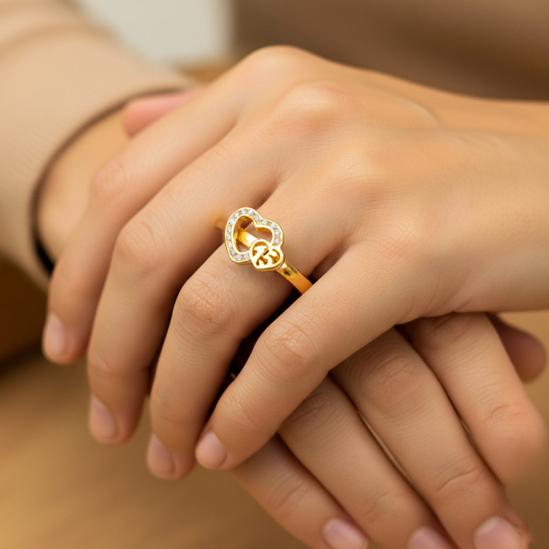 Mano de mujer usando un anillo con corazones en el centro en oro amarillo de 18 quilates con cristales de color blanco de Joyería Caracas. 