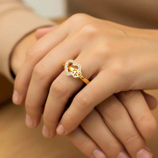 Mano de mujer usando un anillo con corazones en el centro en oro amarillo de 18 quilates con cristales de color blanco de Joyería Caracas. 