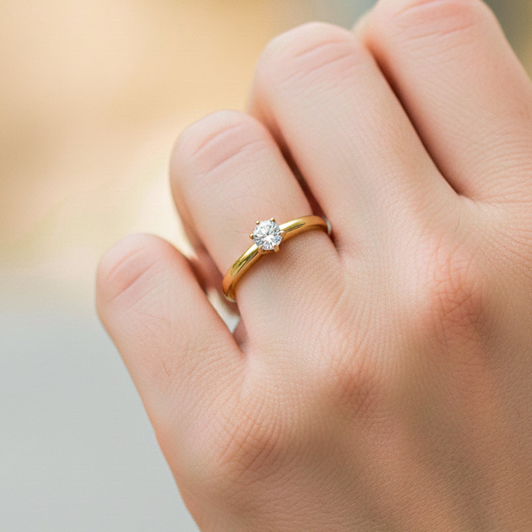 Mano de modelo usando un anillo en oro amarillo de 18 quilates con Moissanite de Joyería Caracas. 
