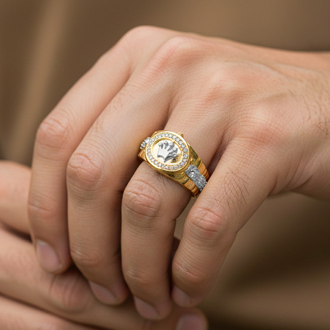 Mano de hombre usando un anillo en forma de corona en oro amarillo y blanco de 18 quilates de Joyería Caracas. 