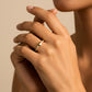 Mano de mujer usando un anillo con forma de corona en el centro en oro amarillo de 18 quilates y cristales en los laterales de color blanco de Joyería Caracas. 