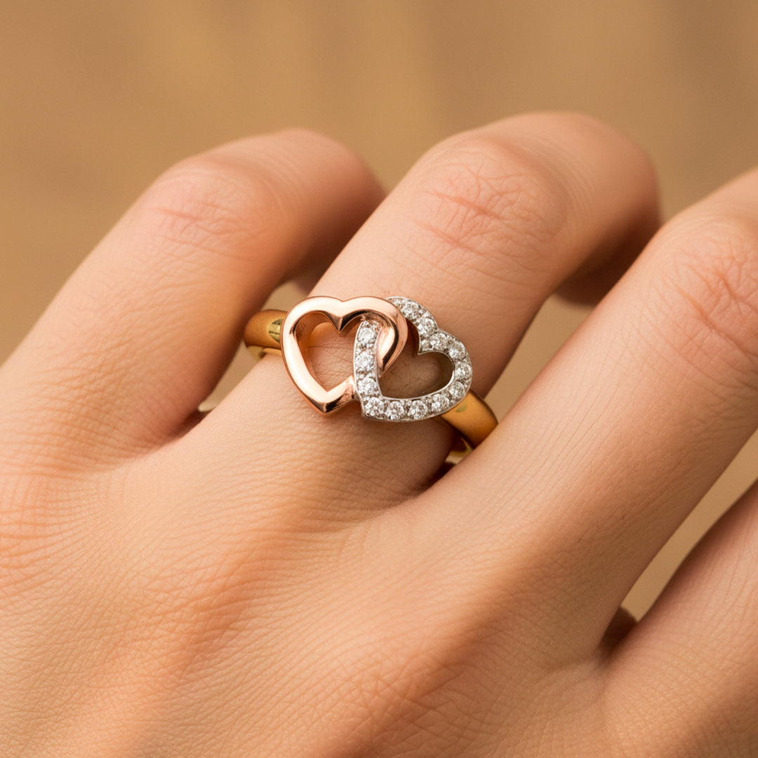 Mano de mujer usando un anillo 3 oros de 18 quilates con 2 corazones entrelazados entre ellos en el centro de Joyería Caracas.