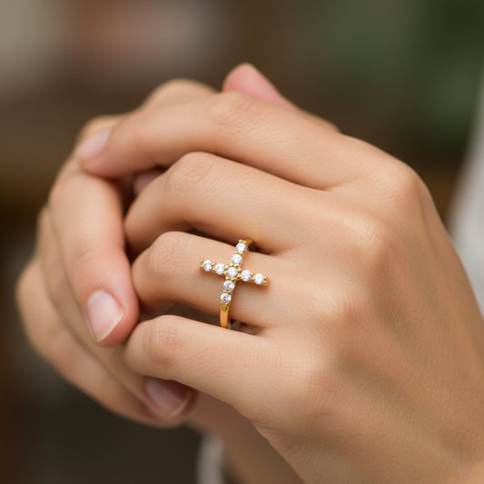 Mano de mujer usando un anillo en oro amarillo de 18 quilates con cristales de color blanco de Joyería Caracas. 