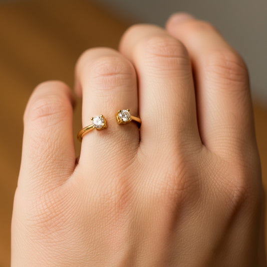 Mano de modelo usando un anillo en oro amarillo de 18 quilates con 2 cristales de color blanco de Joyería Caracas.
