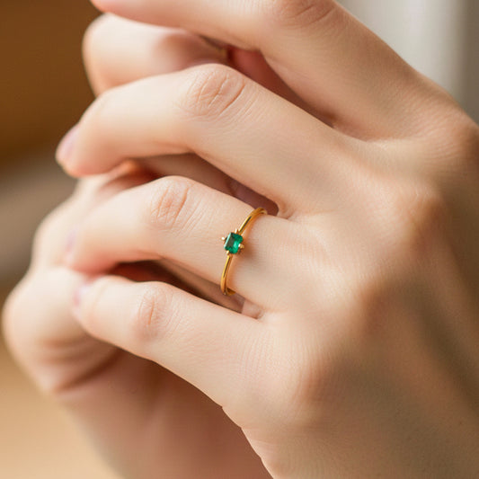 Mano de modelo usando un anillo en oro amarillo de 18 quilates con Esmeralda de Joyería Caracas. 