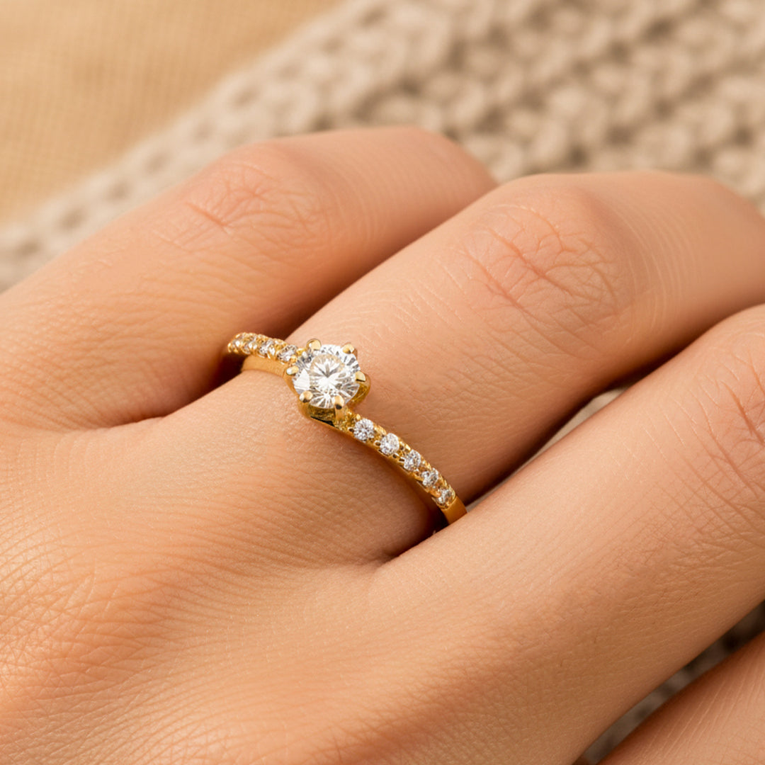 Mano de mujer usando un anillo diseño deep navy en oro amarillo de 18 quilates con moissanites de color blanco de Joyería Caracas. 