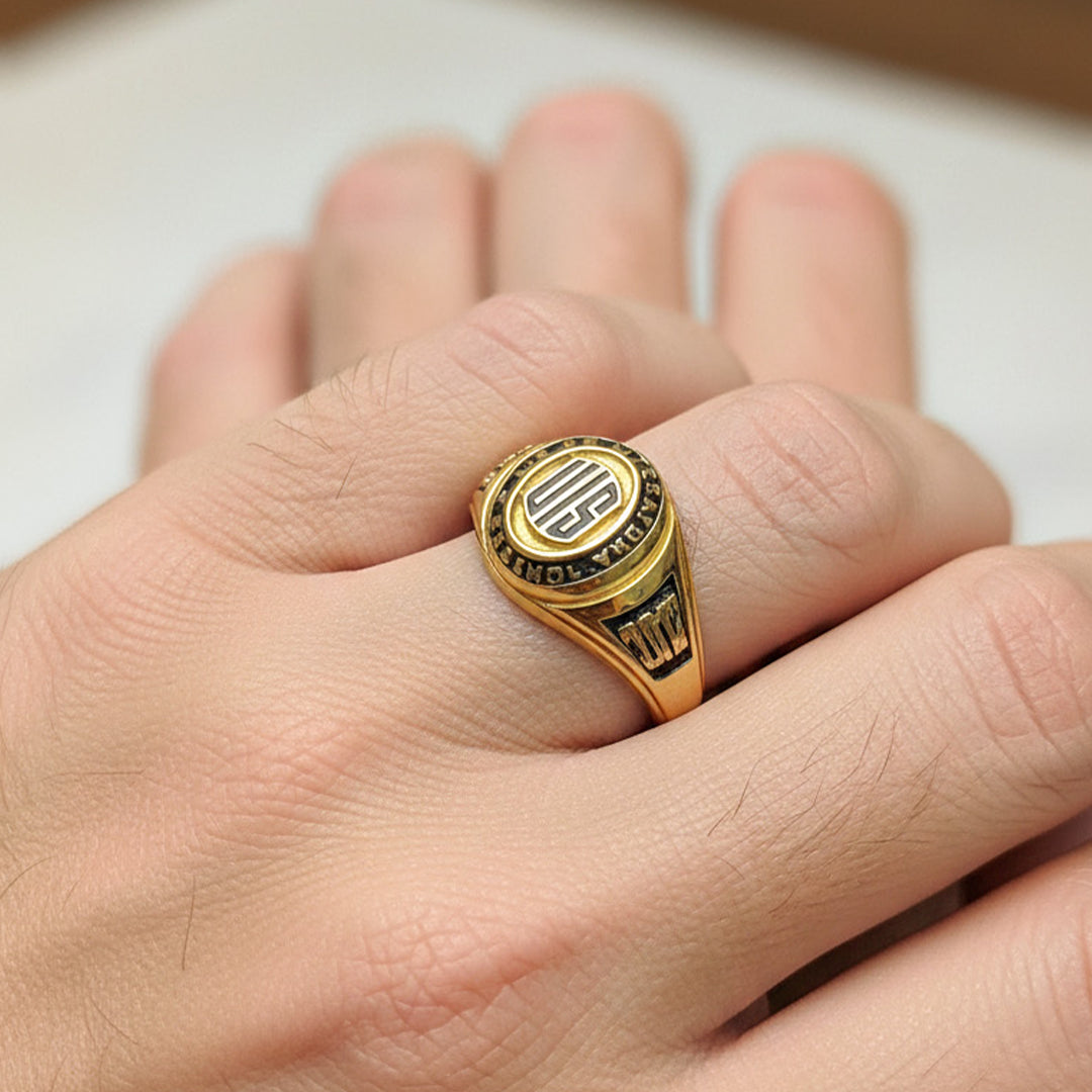 Mano de hombre usando un anillo de grado en oro amarillo de 18 quilates de Joyería Caracas. 