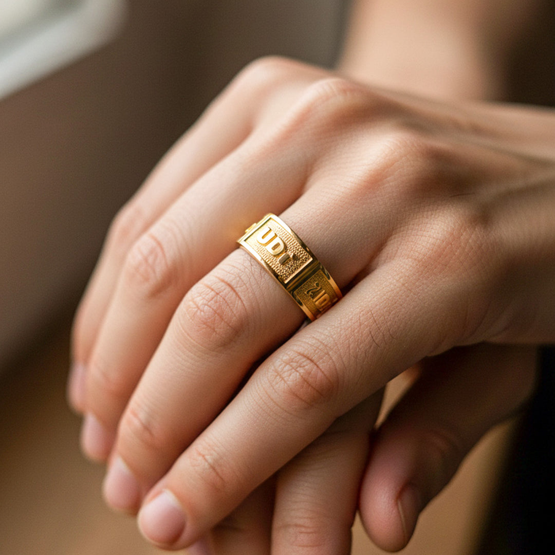 Mano de modelo usando un anillo de grado tipo argolla personalizado de la UDI en oro amarillo de 18 quilates de Joyería Caracas. 