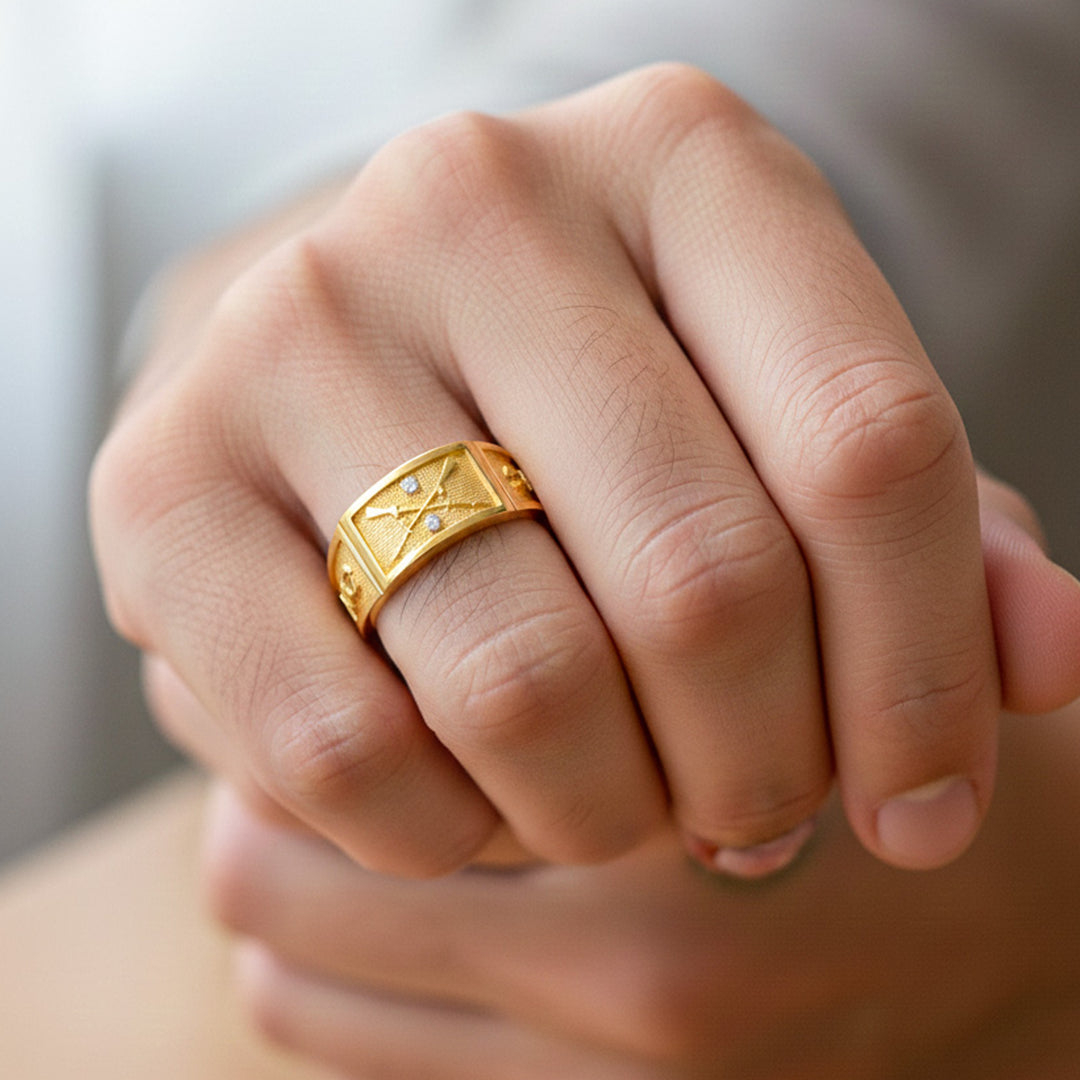 Mano de hombre usando un anillo de grado tipo argolla de la armada en oro amarillo de 18 quilates de Joyería Caracas. 